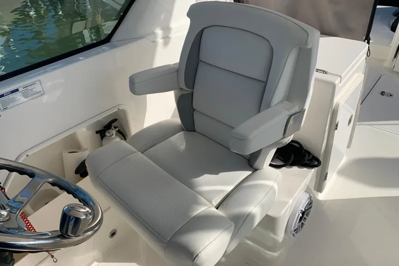 Slide: The Image of Captain's chair on 2023 Pursuit DC 266 Dual Console boat, featuring sleek design and comfort. - 10