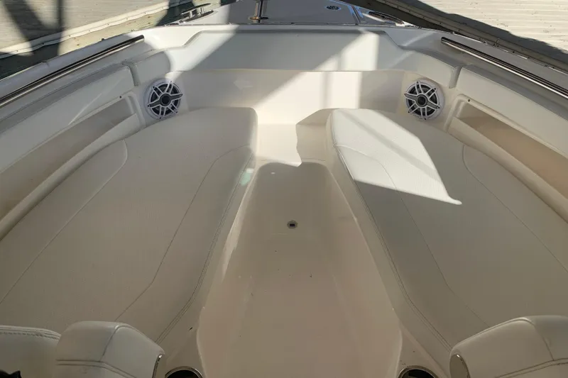 Slide: The Image of 2023 Pursuit DC 266 Dual Console boat interior with cushioned seating and speakers. - 16