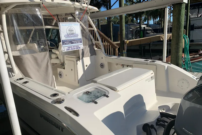 Slide: The Image of 2023 Pursuit DC 266 Dual Console boat docked with sales sign displayed. - 20