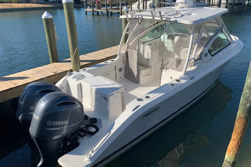 Slide: The Image of 2023 Pursuit DC 266 Dual Console boat docked with twin Yamaha engines. - 4