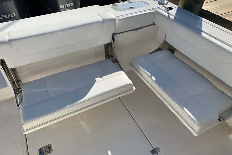 Slide: The Image of 2023 Pursuit DC 266 Dual Console boat seating area with white cushioned seats. - 7