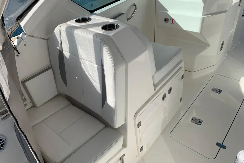 Slide: The Image of 2023 Pursuit DC 266 Dual Console boat interior with white seating and cup holders. - 8