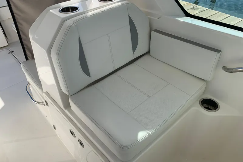 Slide: The Image of 2023 Pursuit DC 266 Dual Console boat seat with cup holders and white upholstery. - 9