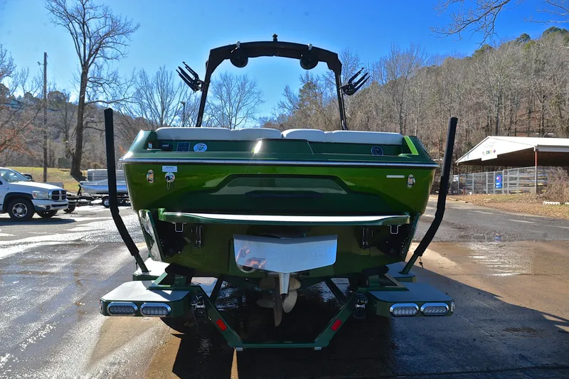 Slide: The Image of 2022 Axis A22 boat, green, rear view, parked outdoors on a sunny day. - 13