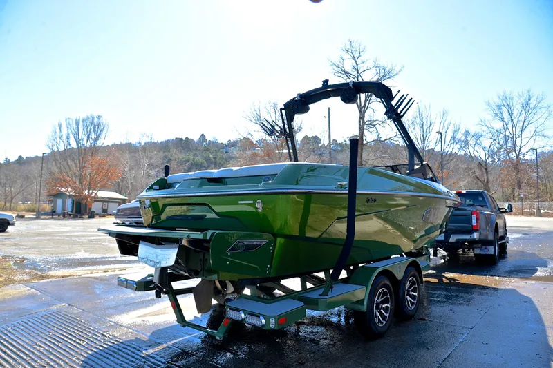 Slide: The Image of 2022 Axis A22 green boat on trailer, parked outdoors in sunny setting. - 14
