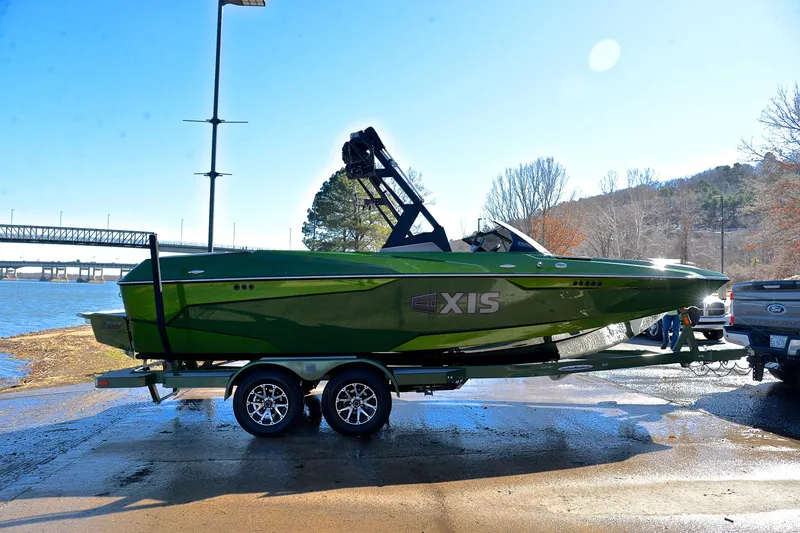 Slide: The Image of 2022 Axis A22 green boat on trailer by a lake, ready for launch. - 15
