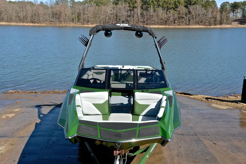 Slide: The Image of 2022 Axis A22 boat in green, docked by a serene lake. - 17