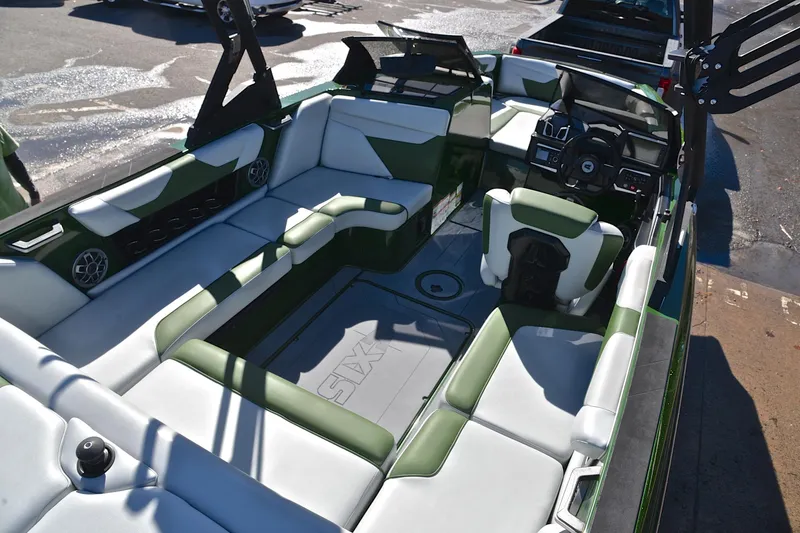 Slide: The Image of 2022 Axis A22 boat interior with green and white seating, modern dashboard, and spacious layout. - 19