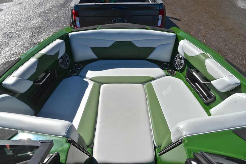 Slide: The Image of 2022 Axis A22 boat interior with green and white seating, cup holders, and speakers. - 21