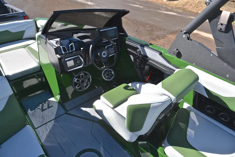Slide: The Image of 2022 Axis A22 boat interior with green and white seating, modern dashboard, and steering wheel. - 26