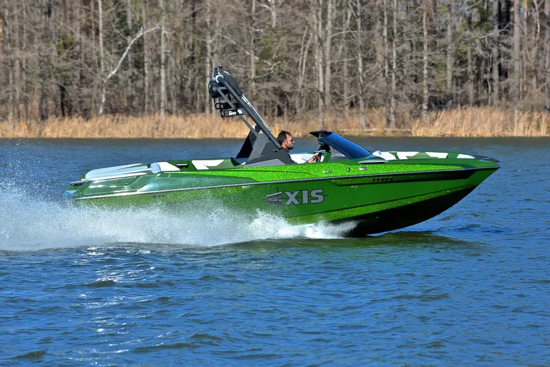 Slide: The Image of 2022 Axis A22 green speedboat cruising on a lake with forest background. - 3