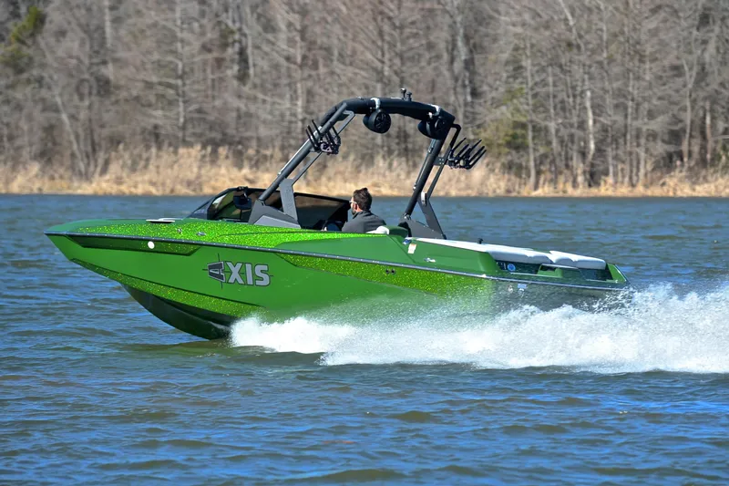 Slide: The Image of 2022 Axis A22 green boat cruising on a lake with trees in the background. - 4