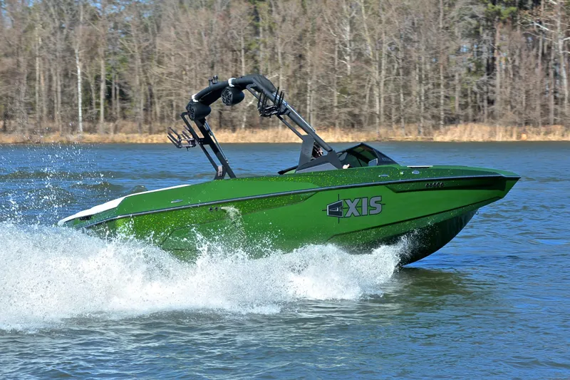 Slide: The Image of 2022 Axis A22 green boat cruising on a lake with trees in the background. - 5