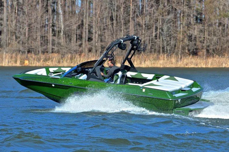 Slide: The Image of 2022 Axis A22 boat cruising on a lake with forest backdrop. - 6