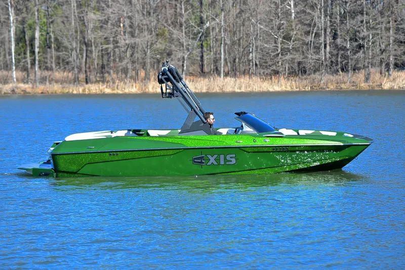 Slide: The Image of 2022 Axis A22 green boat cruising on a lake with forest background. - 7