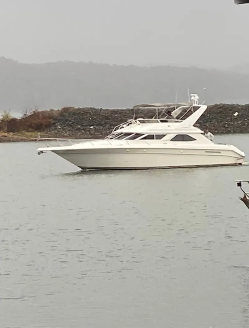 Slide: The Image of 1996 Sea Ray 440 Express Bridge on calm water. - 2