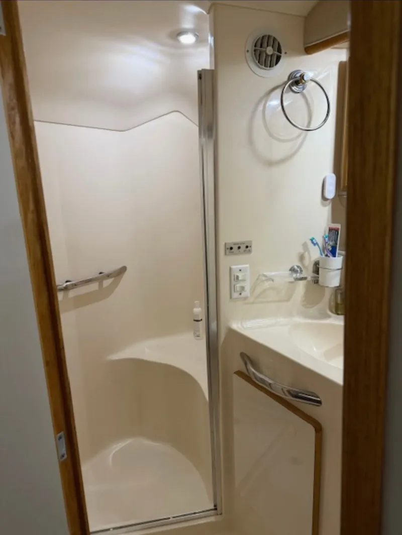 Slide: The Image of 1996 Sea Ray 440 Express Bridge bathroom with shower and sink. - 27
