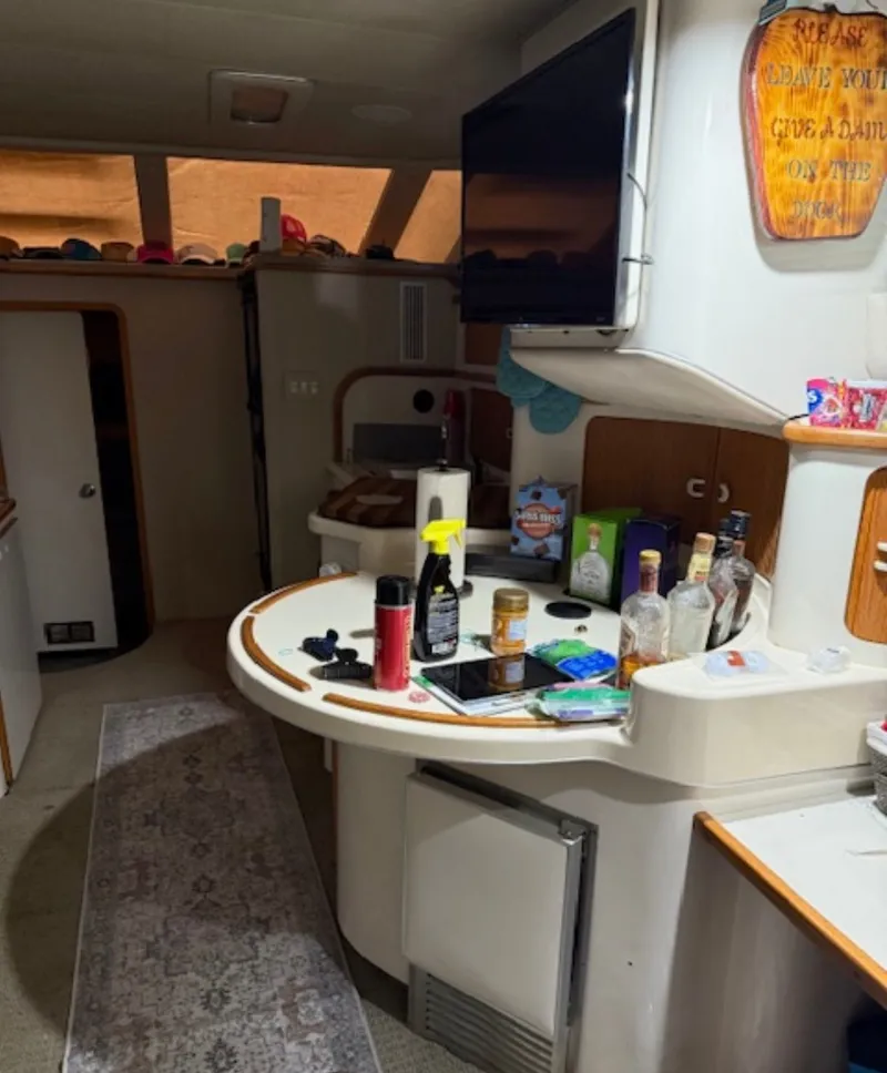 Slide: The Image of Interior of a 1996 Sea Ray 440 Express Bridge with bar and TV. - 28