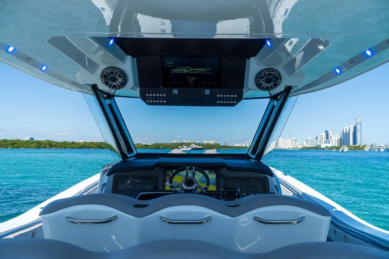 Slide: The Image of Cockpit view of 2023 MTI 50v boat with city skyline and blue ocean. - 12