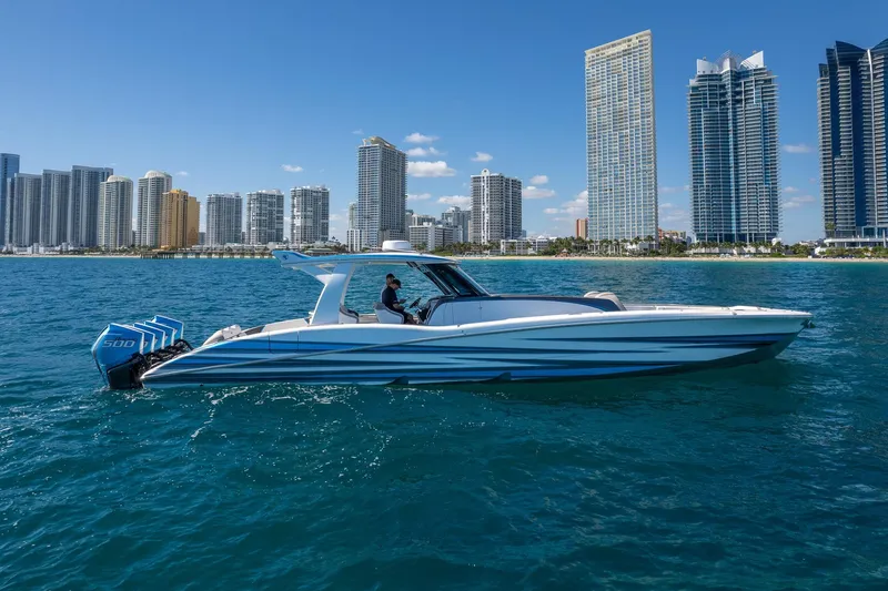 Slide: The Image of 2023 MTI 50v boat cruising near city skyline on clear blue water. - 47
