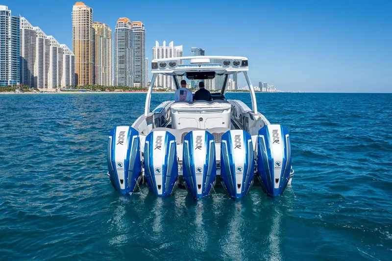Slide: The Image of 2023 MTI 50v boat with five engines on ocean, city skyline in background. - 52