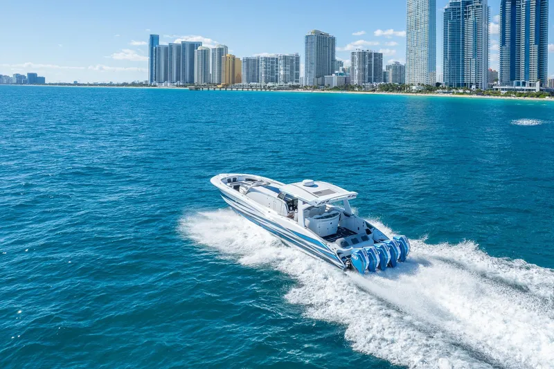 Slide: The Image of 2023 MTI 50v boat cruising near city skyline on blue ocean waters. - 56