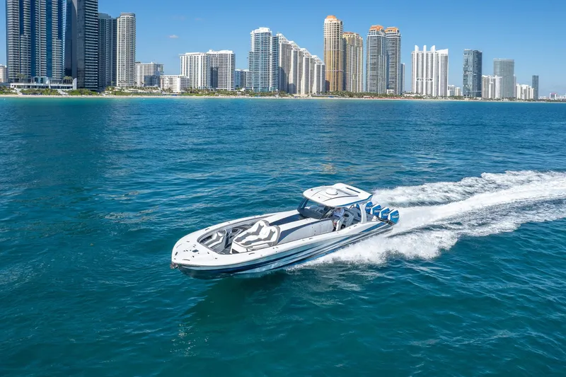 Slide: The Image of 2023 MTI 50v boat cruising near city skyline on clear blue water. - 59