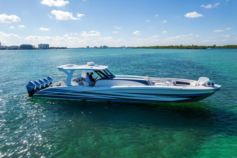 Slide: The Image of 2023 MTI 50v boat cruising on clear blue water under a sunny sky. - 61