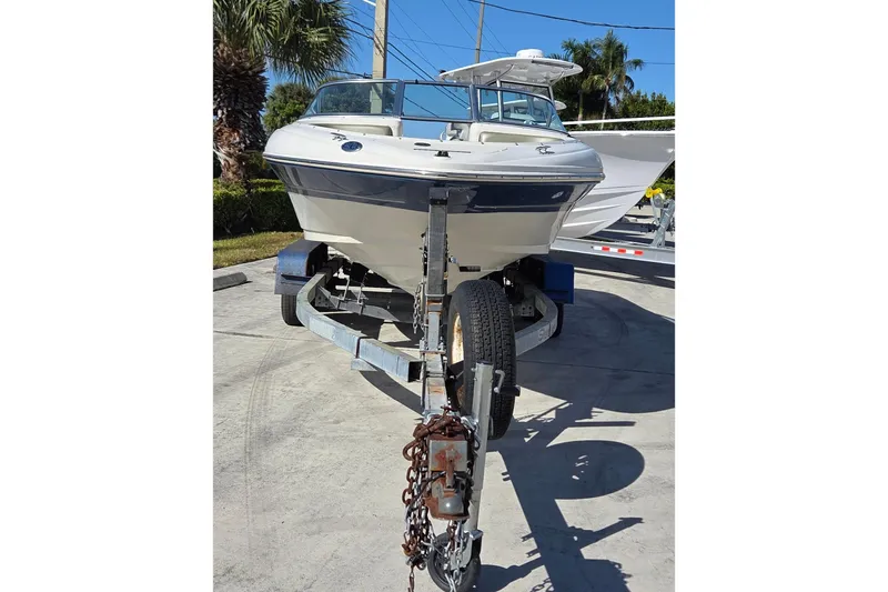Slide: The Image of 2004 Sea Ray 200 Sport boat on trailer, parked outdoors under clear sky. - 13