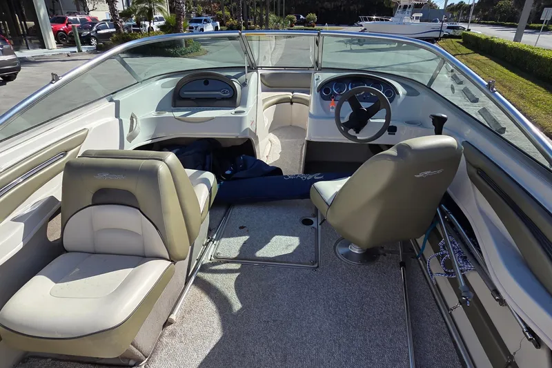 Slide: The Image of 2004 Sea Ray 200 Sport boat interior with beige seating and steering console. - 9