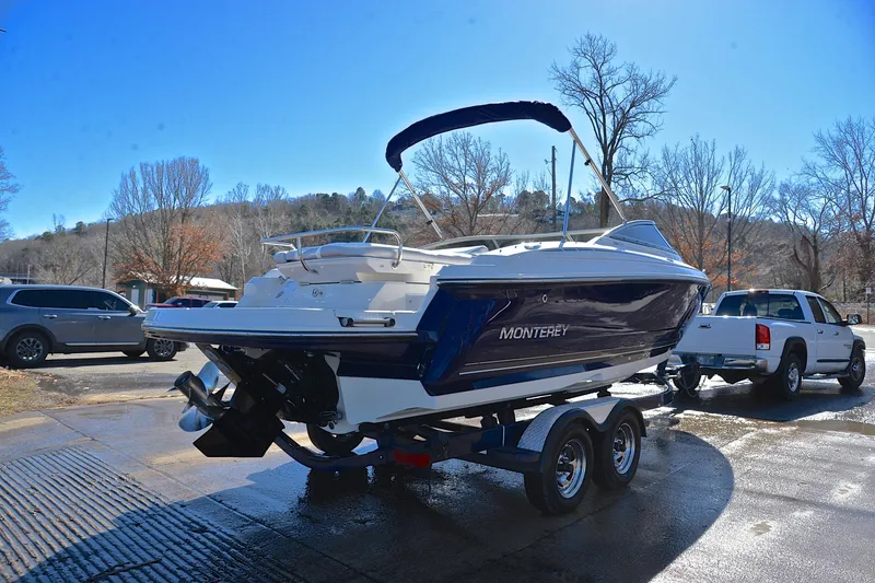 Slide: The Image of 2011 Monterey 234FS boat on trailer, parked outdoors on a sunny day. - 13
