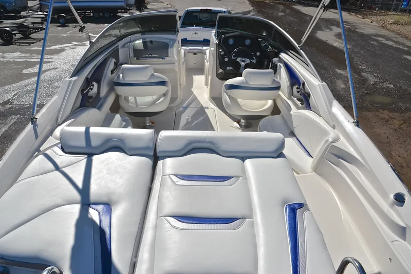 Slide: The Image of 2011 Monterey 234FS boat interior with white and blue seating, steering console, and spacious layout. - 17