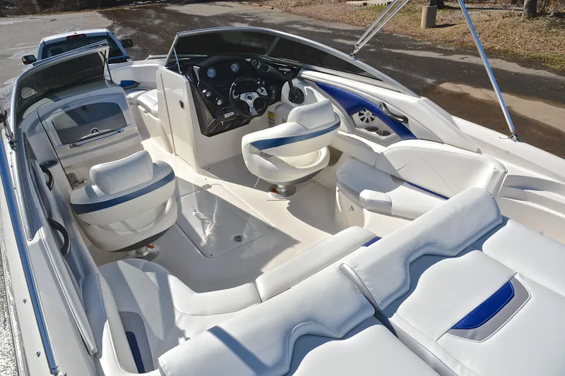 Slide: The Image of 2011 Monterey 234FS boat interior with white and blue seating, steering console, and spacious layout. - 24