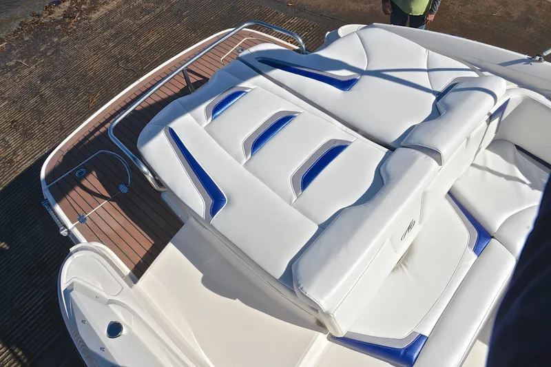 Slide: The Image of 2011 Monterey 234FS boat with white and blue cushioned seating on deck. - 25