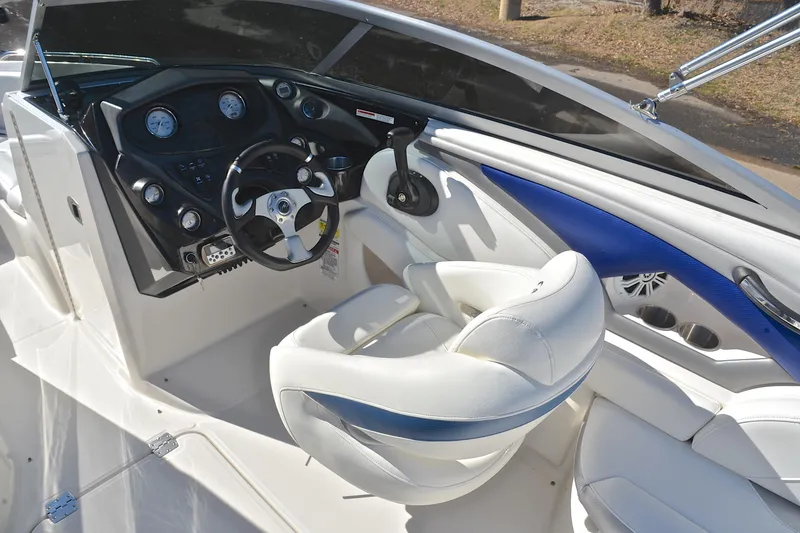 Slide: The Image of Interior of 2011 Monterey 234FS boat with steering wheel and white seating. - 26
