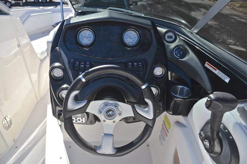 Slide: The Image of 2011 Monterey 234FS boat dashboard with steering wheel and control panel. - 27