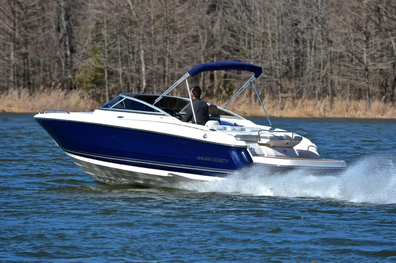 Slide: The Image of 2011 Monterey 234FS boat cruising on a lake with trees in the background. - 3