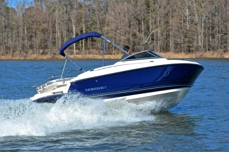 Slide: The Image of 2011 Monterey 234FS boat cruising on a lake with forested background. - 4