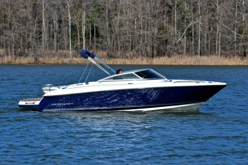 Slide: The Image of 2011 Monterey 234FS boat cruising on a lake with forested shoreline. - 6