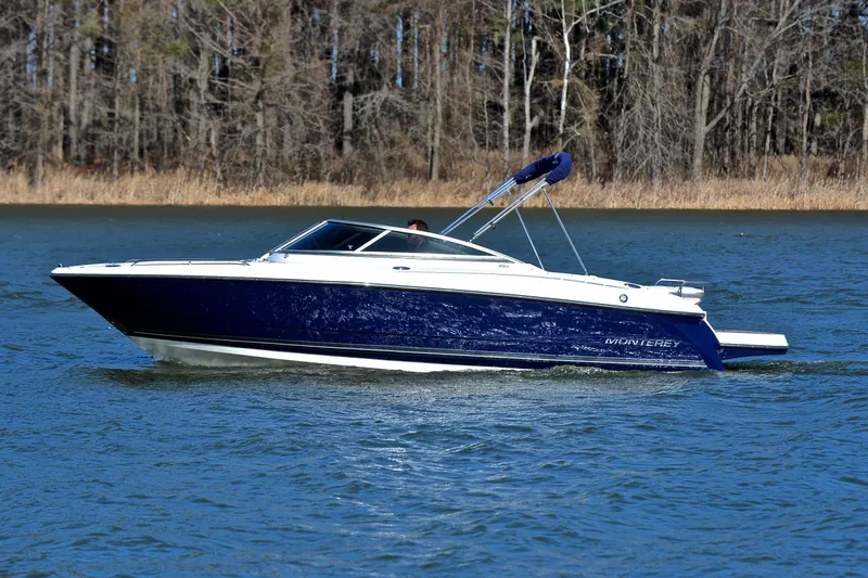 Slide: The Image of 2011 Monterey 234FS boat cruising on a lake with forested background. - 8