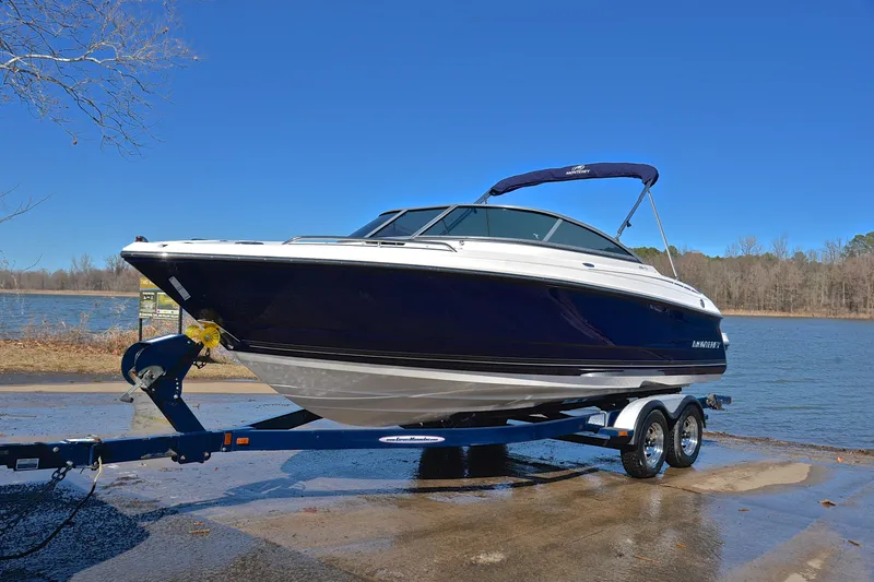 Slide: The Image of 2011 Monterey 234FS boat on trailer by a lake under clear blue sky. - 9