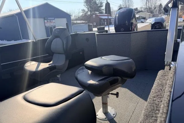 Slide: The Image of 2026 Crestliner 1850 Commander boat interior with seating and motor, in a sunny outdoor setting. - 6