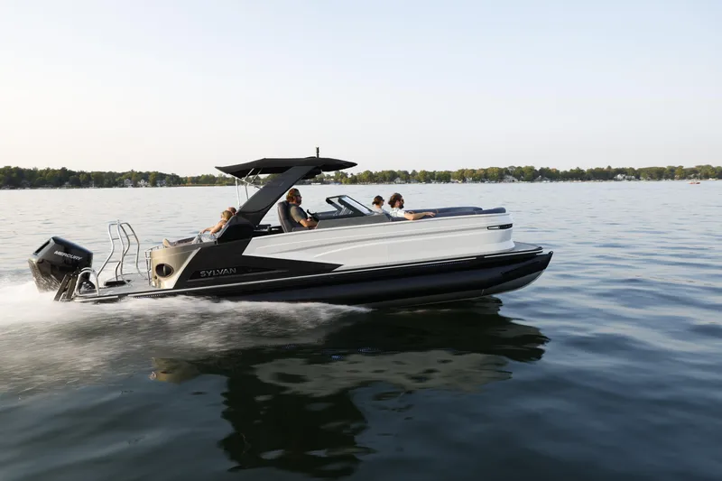 Slide: The Image of 2025 Sylvan M5 CLZ DC pontoon boat cruising on a serene lake. - 29