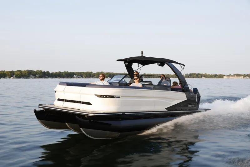 Slide: The Image of 2025 Sylvan M5 CLZ DC pontoon boat cruising on a serene lake. - 30