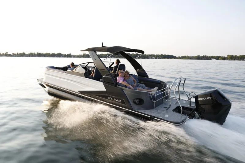 Slide: The Image of 2025 Sylvan M5 CLZ DC pontoon boat cruising on a lake with passengers. - 8