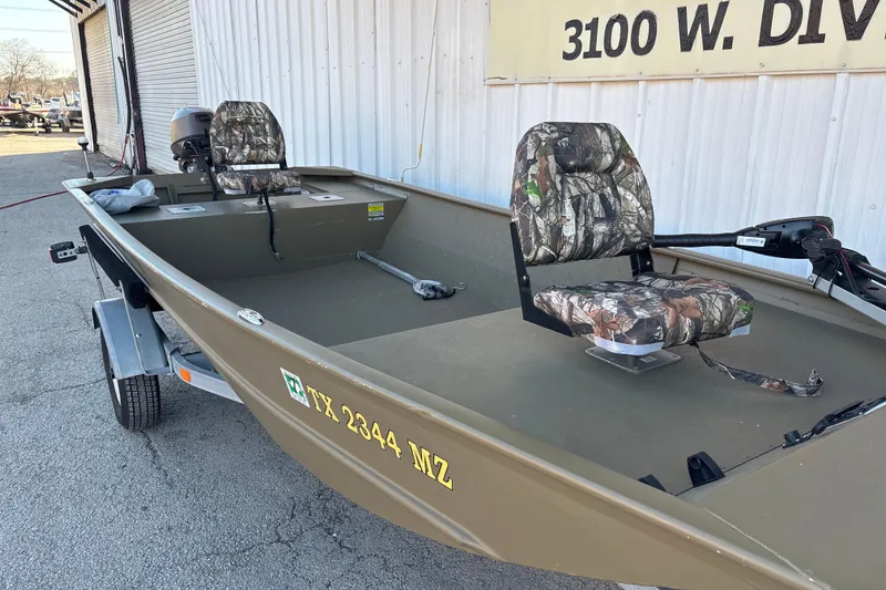 Slide: The Image of 2025 G3 Gator Tough 1652 VBW boat with camouflage seats, parked outside a building. - 10