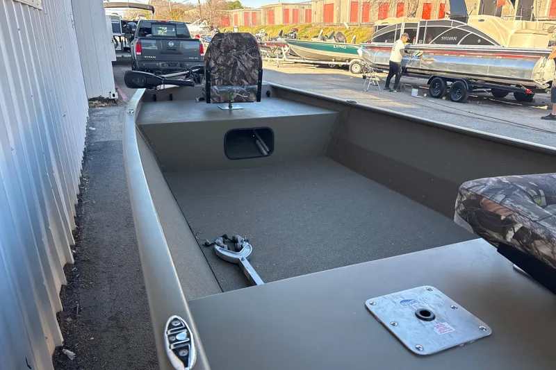 Slide: The Image of 2025 G3 Gator Tough 1652 VBW boat with camo seats, parked outdoors. - 16