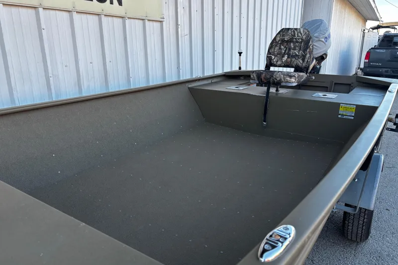 Slide: The Image of 2025 G3 Gator Tough 1652 VBW boat with camo seat, parked outside. - 63