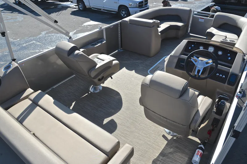 Slide: The Image of 2023 Bennington L23 pontoon boat interior with beige seating and modern dashboard. - 19
