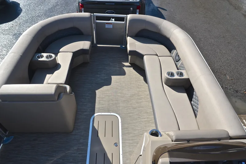 Slide: The Image of 2023 Bennington L23 pontoon boat interior with beige seating and cup holders. - 21